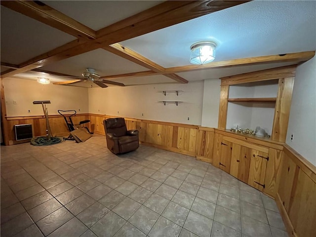 interior space with coffered ceiling, a textured ceiling, light tile patterned floors, beamed ceiling, and wood walls