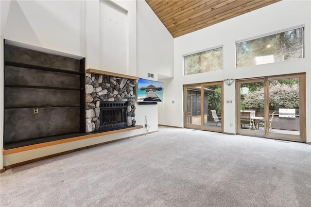 unfurnished living room with carpet, a stone fireplace, wood ceiling, and high vaulted ceiling