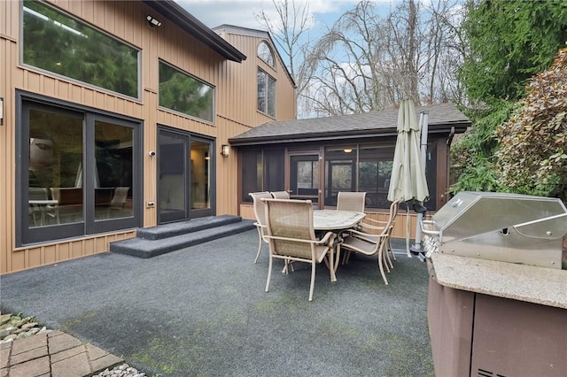 view of patio featuring a grill and a sunroom