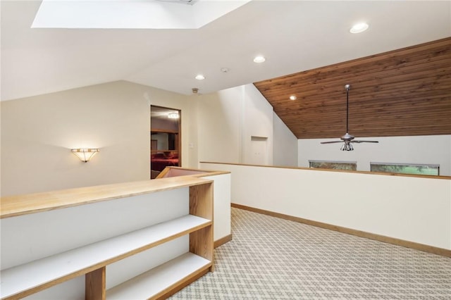 hallway with light carpet, lofted ceiling with skylight, and wood ceiling