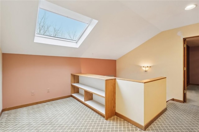 bonus room with light colored carpet and vaulted ceiling with skylight