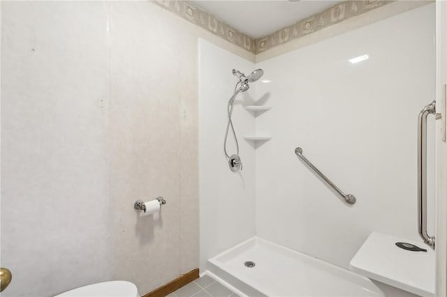 bathroom featuring tile patterned flooring, a shower, and toilet