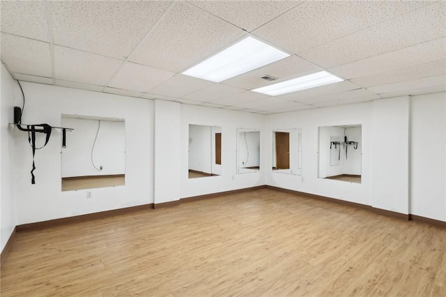 unfurnished room with a paneled ceiling and light hardwood / wood-style floors