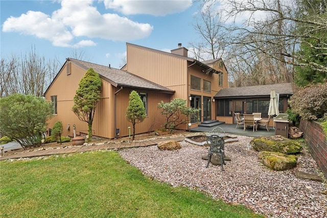 back of property featuring a sunroom, a patio area, and a yard