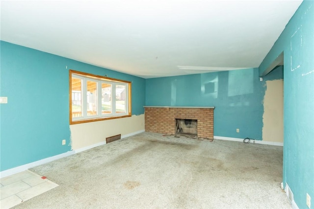 unfurnished living room featuring carpet and a brick fireplace