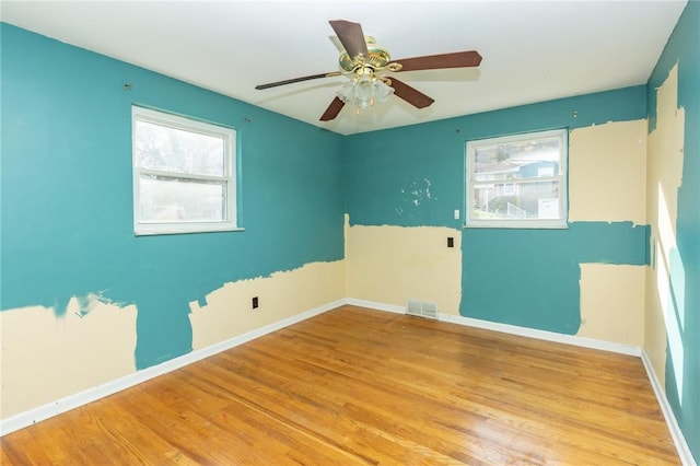 unfurnished room with ceiling fan, a wealth of natural light, and light hardwood / wood-style flooring