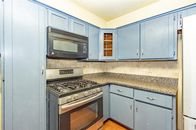 kitchen with decorative backsplash, blue cabinets, light wood-type flooring, and stainless steel gas range