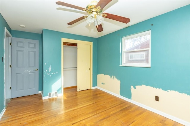 unfurnished bedroom with ceiling fan, a closet, and light hardwood / wood-style floors