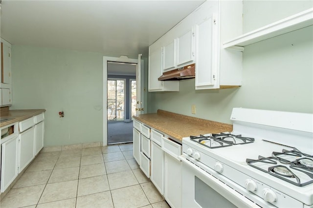 kitchen featuring white gas stove, white cabinetry, and light tile patterned floors