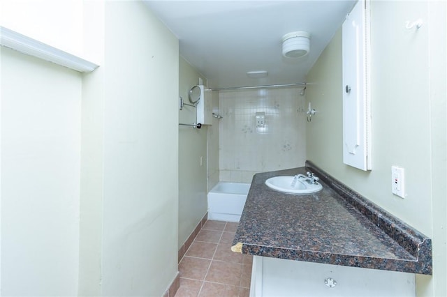 bathroom with tile patterned flooring, tiled shower / bath combo, and sink