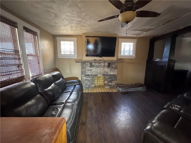 living room featuring ceiling fan, wood-type flooring, a fireplace, and a wealth of natural light