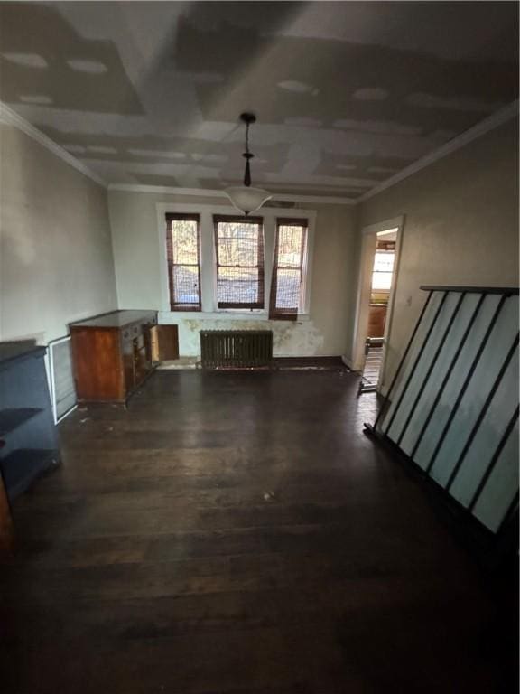 unfurnished living room featuring dark hardwood / wood-style floors, radiator heating unit, and ornamental molding