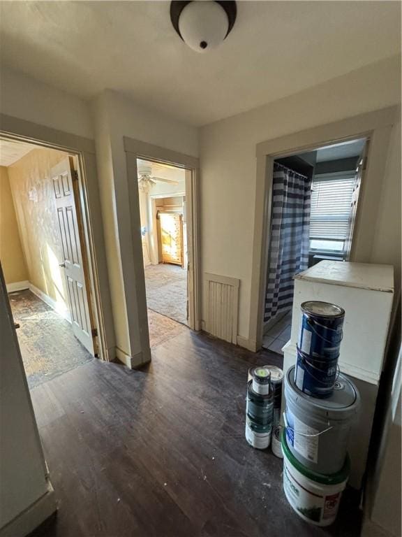 corridor with dark hardwood / wood-style flooring and radiator heating unit