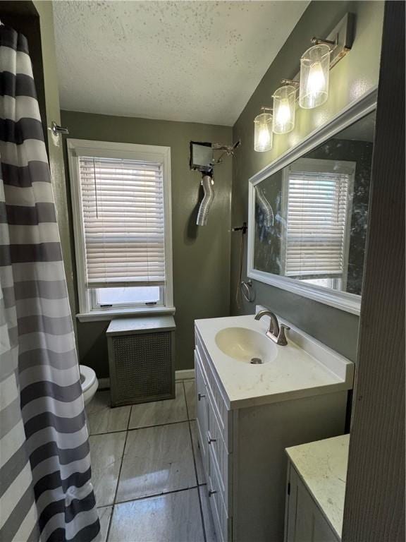 bathroom featuring tile patterned flooring, a textured ceiling, vanity, and plenty of natural light