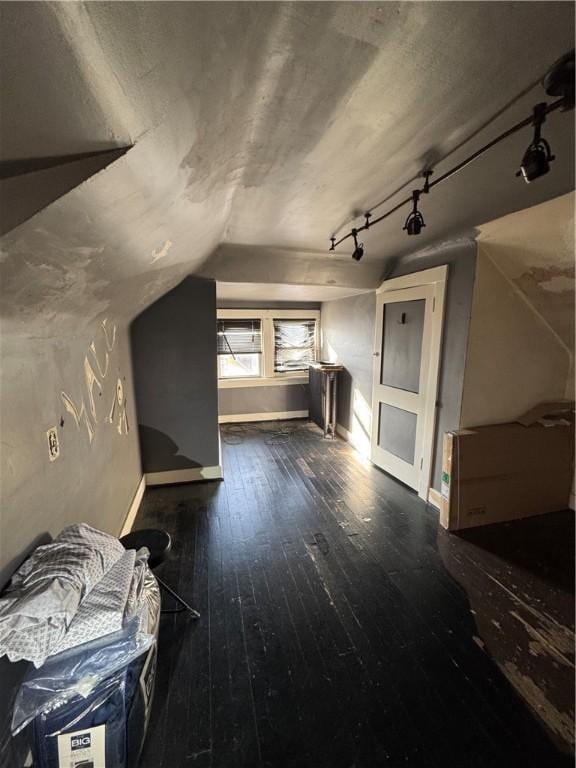 bonus room with lofted ceiling and dark wood-type flooring