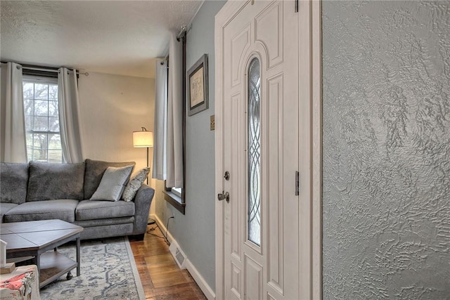 foyer entrance with hardwood / wood-style flooring and a textured ceiling