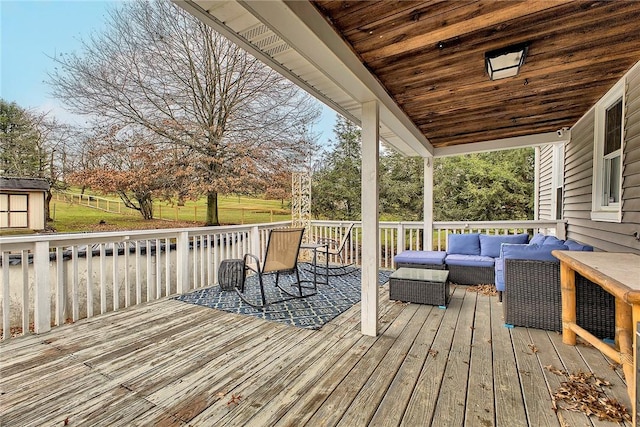 wooden deck with outdoor lounge area and a shed