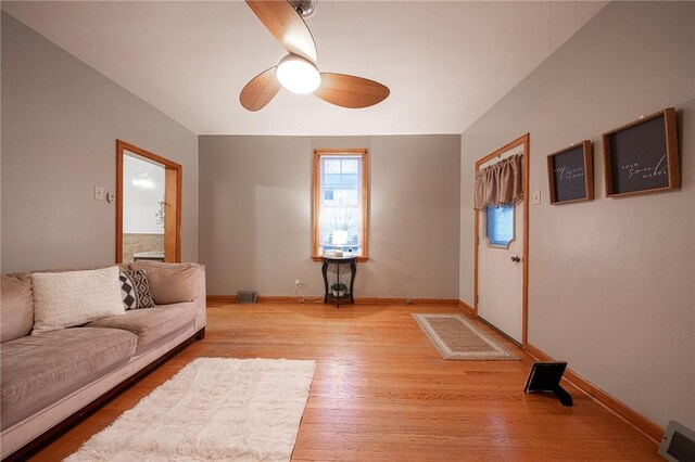 living room with light hardwood / wood-style floors and ceiling fan