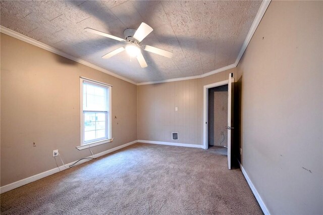 empty room with carpet flooring, ceiling fan, and crown molding