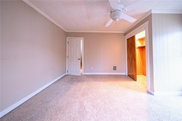 empty room featuring ceiling fan, light carpet, and crown molding