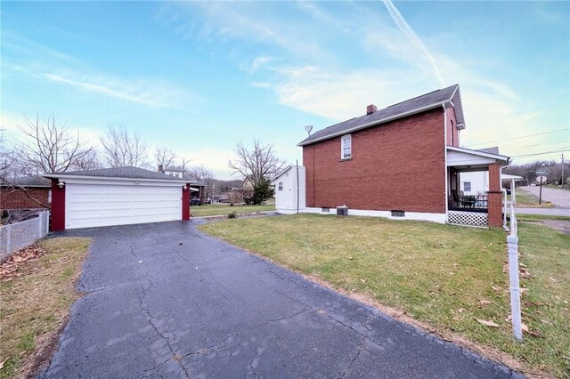 view of home's exterior featuring a yard, covered porch, a garage, and an outdoor structure