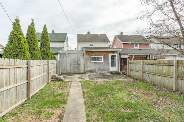 back of house with a patio area and a yard