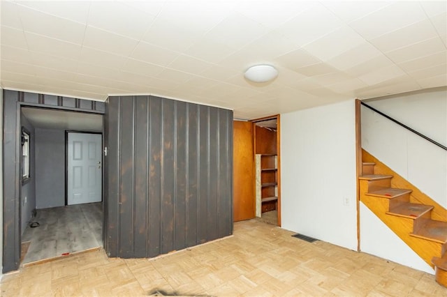 basement with wooden walls and light parquet floors