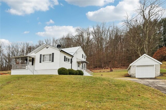 view of home's exterior with a lawn, a garage, an outbuilding, and covered porch