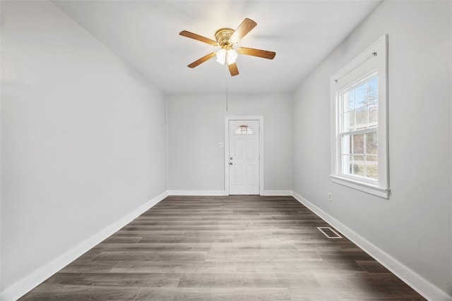 empty room with ceiling fan and dark hardwood / wood-style flooring