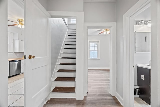 stairs featuring ceiling fan and hardwood / wood-style floors