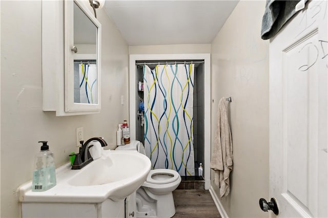 bathroom featuring hardwood / wood-style floors, vanity, toilet, and walk in shower