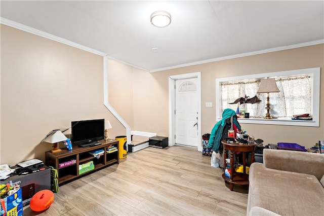 recreation room featuring ornamental molding and light hardwood / wood-style flooring