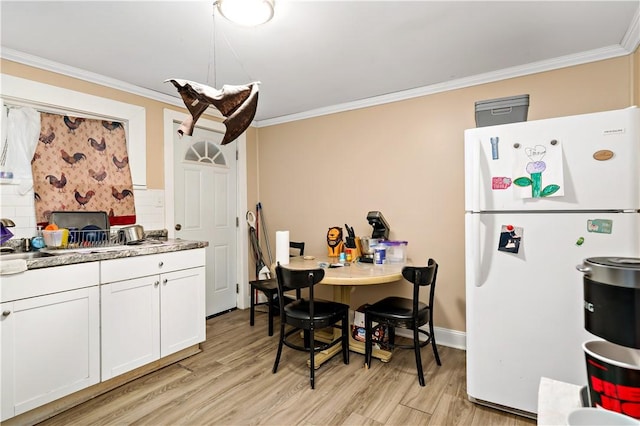 kitchen featuring ornamental molding, white cabinets, light wood-type flooring, and white refrigerator