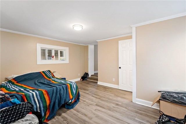 bedroom featuring crown molding and light wood-type flooring