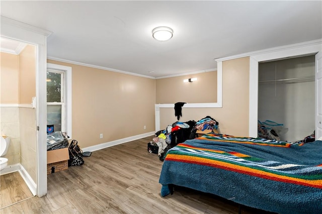 bedroom with hardwood / wood-style flooring, a closet, and ornamental molding