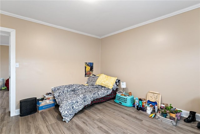 bedroom with crown molding and hardwood / wood-style floors