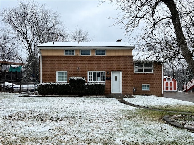 snow covered property with a storage shed