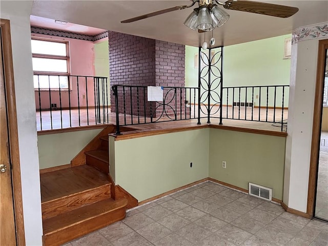 stairs featuring ceiling fan