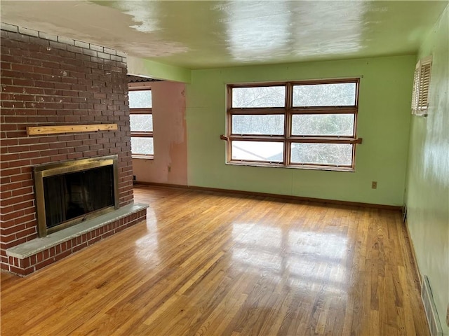 unfurnished living room with a fireplace and light hardwood / wood-style floors