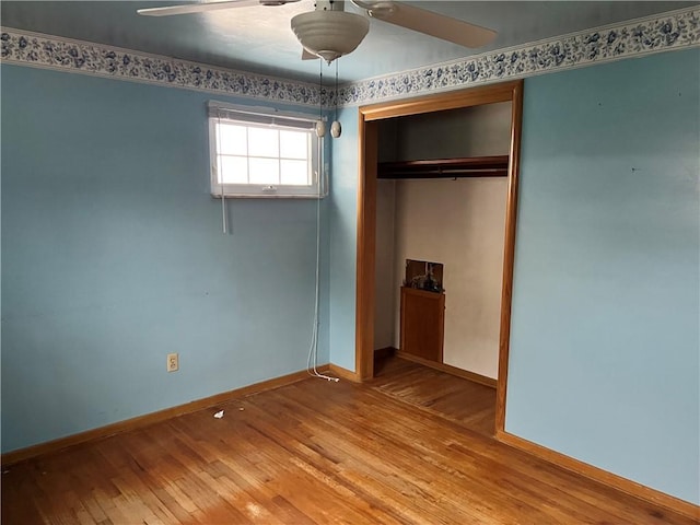 unfurnished bedroom featuring a closet, hardwood / wood-style flooring, and ceiling fan