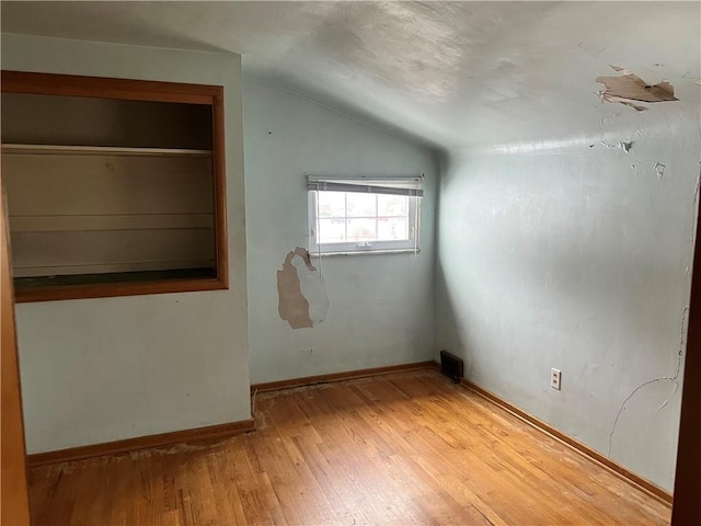 bonus room with light hardwood / wood-style flooring and lofted ceiling