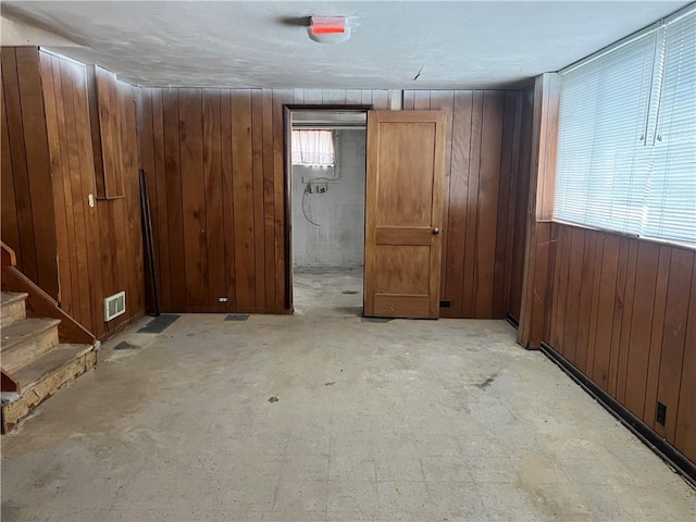 basement featuring wood walls