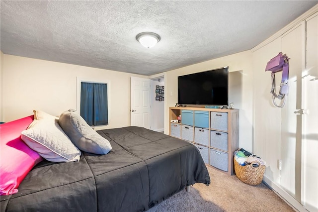 bedroom featuring light carpet and a textured ceiling