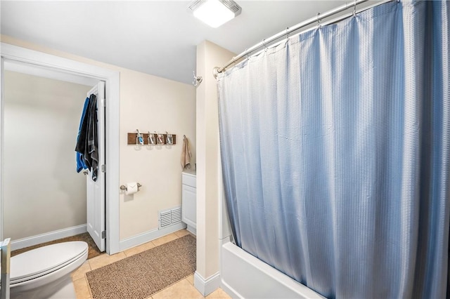 bathroom featuring tile patterned flooring, shower / tub combo, and toilet