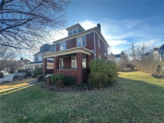 view of side of home with a yard and covered porch