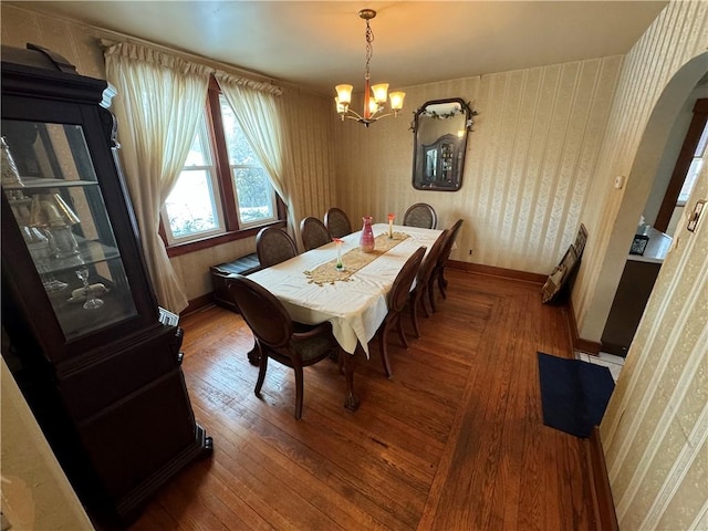 dining space with hardwood / wood-style flooring and an inviting chandelier