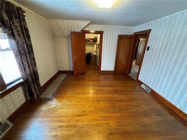 unfurnished room with hardwood / wood-style flooring, a baseboard radiator, and ornamental molding