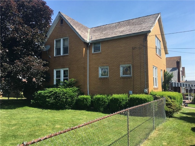 view of side of home with a yard