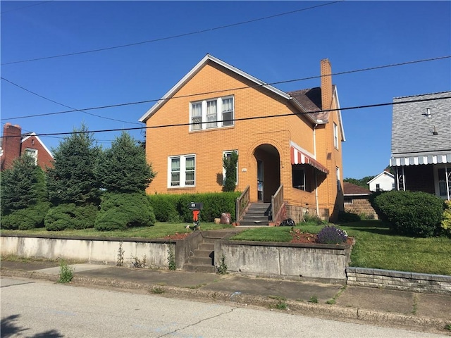 view of front of house with brick siding and a chimney