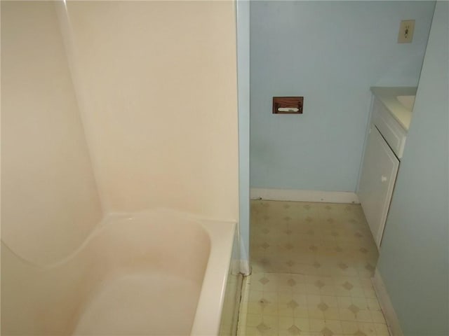 bathroom featuring a washtub and vanity